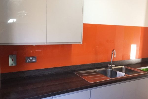 kitchen glass splashback coloured in bright red orange